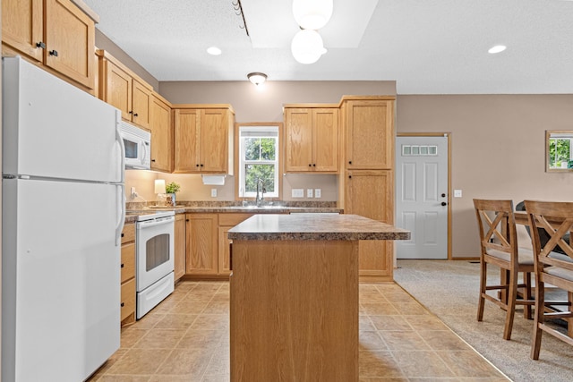 3010 Hazelwood St, Maplewood, MN 55109 - kitchen featuring white appliances, a kitchen island, light brown cabinets, and recessed lighting