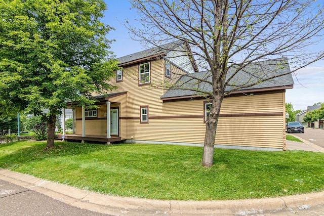 3010 Hazelwood St, Maplewood, MN 55109 - view of side of home with a lawn, a shingled roof, and covered porch