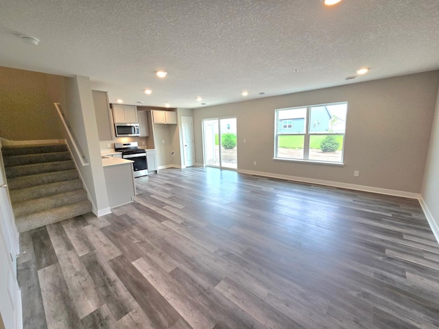 13636 Kaylemore Trl, Rosemount, MN 55068 - unfurnished living room with a textured ceiling, recessed lighting, dark wood finished floors, and stairway
