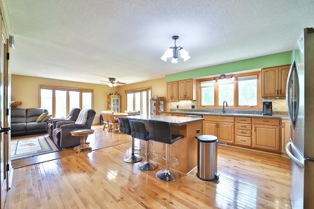 39808 340th Ln, Aitkin, MN 56431 - kitchen with freestanding refrigerator, plenty of natural light, open floor plan, backsplash, and a textured ceiling