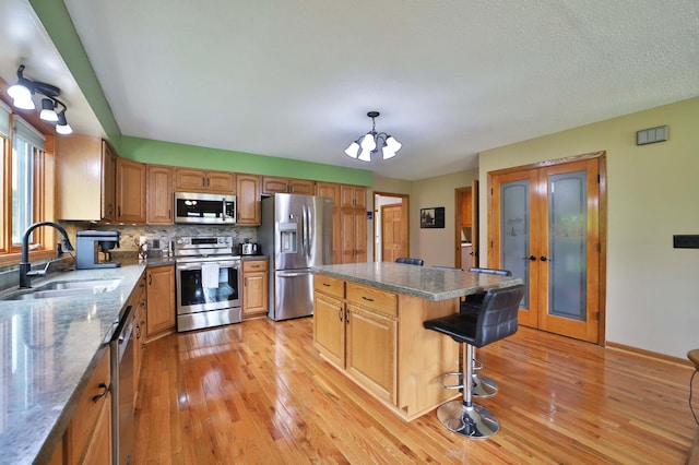 39808 340th Ln, Aitkin, MN 56431 - kitchen featuring appliances with stainless steel finishes, light wood-type flooring, a chandelier, and a breakfast bar