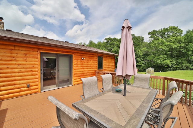 39808 340th Ln, Aitkin, MN 56431 - deck with outdoor dining space, a storage unit, and a yard