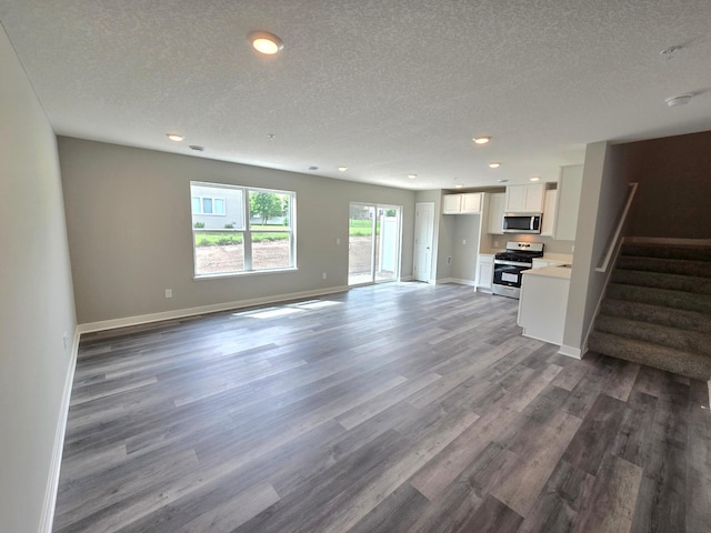 13643 Kaylemore Trl, Rosemount, MN 55068 - unfurnished living room featuring wood finished floors, a textured ceiling, stairs, and recessed lighting