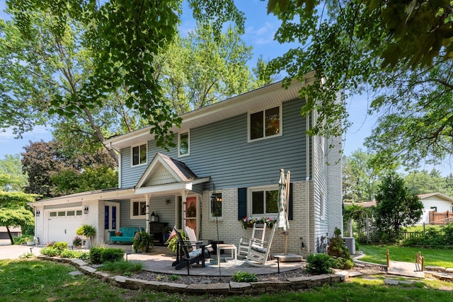 2068 Thorndale Ave, New Brighton, MN 55112 - view of front of property with a garage, brick siding, a front lawn, and a patio area
