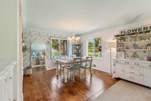 2068 Thorndale Ave, New Brighton, MN 55112 - dining room with wallpapered walls, a chandelier, dark wood-style flooring, and arched walkways