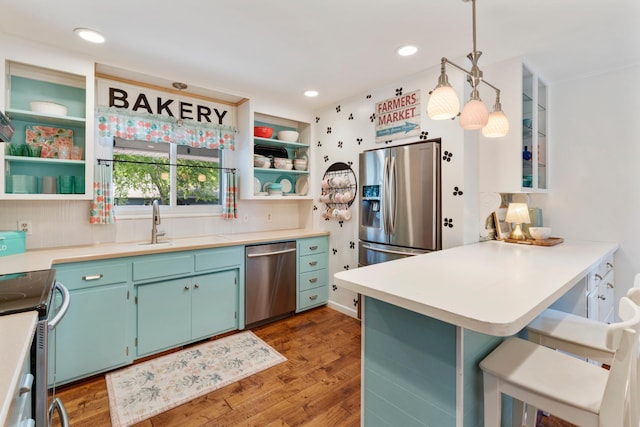2068 Thorndale Ave, New Brighton, MN 55112 - kitchen with appliances with stainless steel finishes, open shelves, a breakfast bar, a peninsula, and wood finished floors