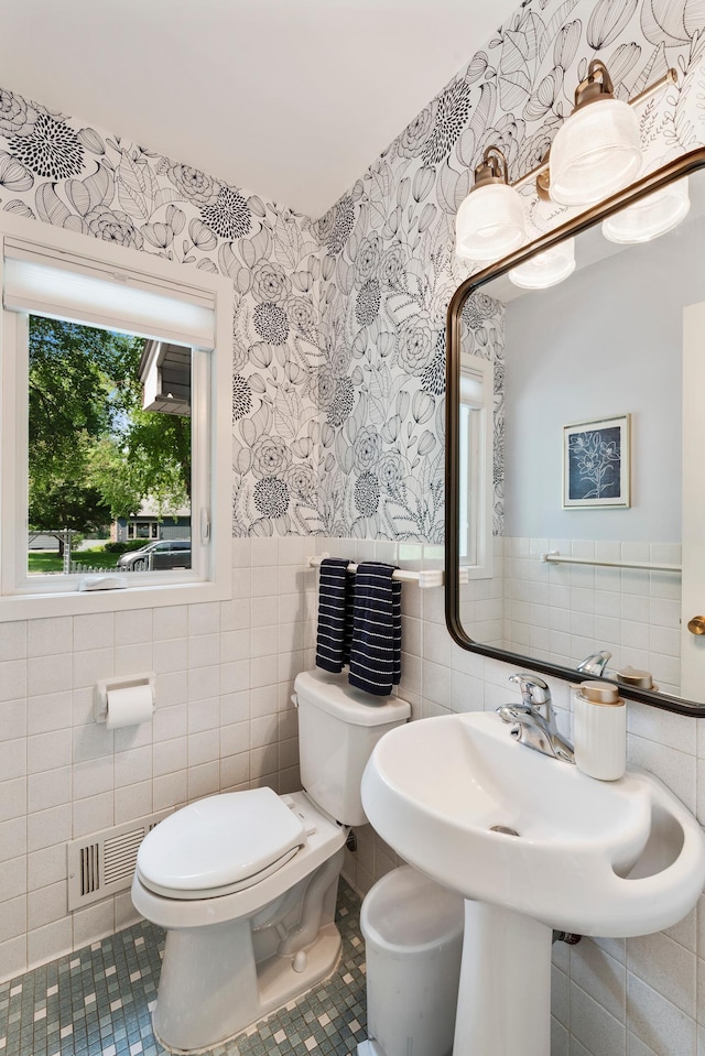 2068 Thorndale Ave, New Brighton, MN 55112 - bathroom featuring wallpapered walls, tile walls, tile patterned floors, and wainscoting