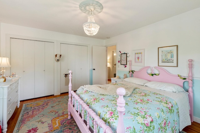 2068 Thorndale Ave, New Brighton, MN 55112 - bedroom with multiple closets, wood finished floors, and a chandelier
