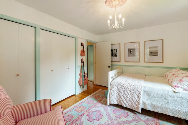 2068 Thorndale Ave, New Brighton, MN 55112 - bedroom featuring multiple closets, light wood-type flooring, and a chandelier
