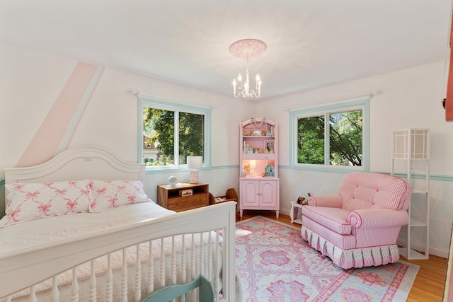 2068 Thorndale Ave, New Brighton, MN 55112 - bedroom with multiple windows, wood finished floors, and a chandelier