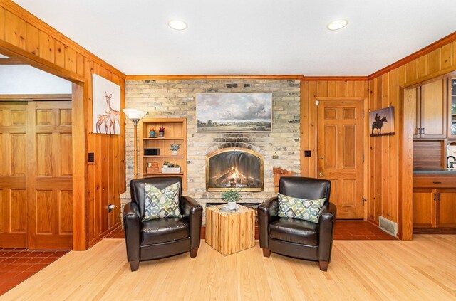 1350 Crestridge Ln, Eagan, MN 55123 - sitting room featuring crown molding, wood walls, a brick fireplace, wood finished floors, and recessed lighting