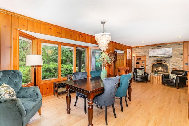 1350 Crestridge Ln, Eagan, MN 55123 - dining room featuring wood walls, a chandelier, light wood-style floors, a fireplace, and ornamental molding