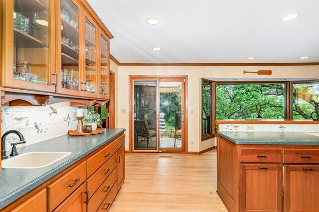 1350 Crestridge Ln, Eagan, MN 55123 - kitchen with light wood-type flooring, decorative backsplash, glass insert cabinets, recessed lighting, and ornamental molding