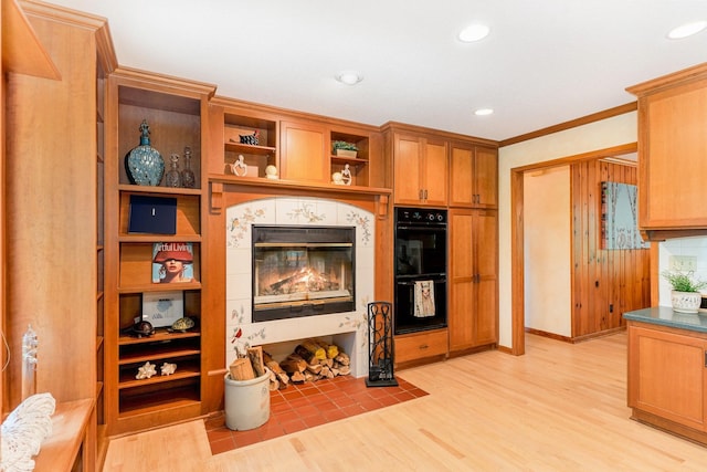 1350 Crestridge Ln, Eagan, MN 55123 - kitchen featuring light wood-type flooring, open shelves, recessed lighting, a tile fireplace, and crown molding