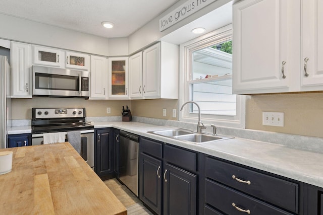 1475 Eldridge Ave E, Maplewood, MN 55109 - kitchen featuring stainless steel appliances, white cabinetry, wooden counters, and dark cabinets