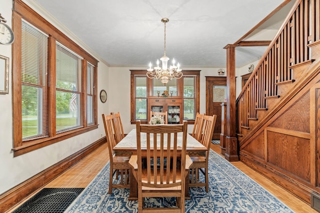 20930 St Francis Blvd NW, Nowthen, MN 55303 - dining area featuring a chandelier, light wood-type flooring, crown molding, and stairs