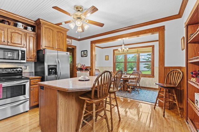 20930 St Francis Blvd NW, Nowthen, MN 55303 - kitchen with appliances with stainless steel finishes, wainscoting, light wood-type flooring, a kitchen breakfast bar, and a center island