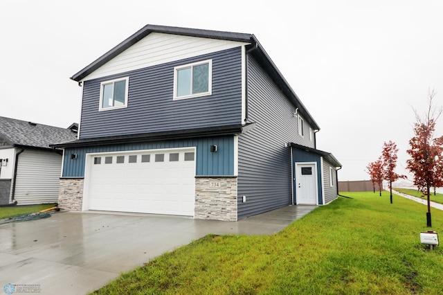 737 2nd Ave, Fargo, ND 58047 - view of front of house with stone siding, board and batten siding, a front yard, an attached garage, and concrete driveway