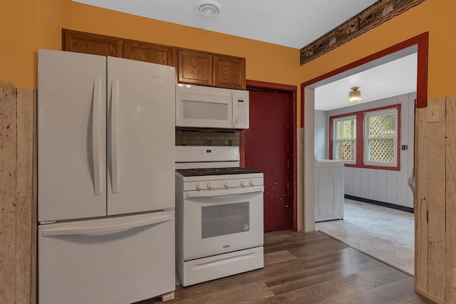200 27th Ave N, Saint Cloud, MN 56303 - kitchen featuring white appliances, washer / clothes dryer, wood finished floors, and brown cabinetry