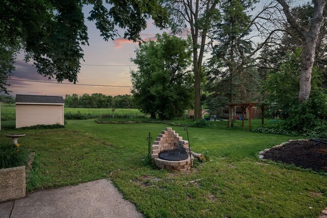 1218 4th Ave SE, Austin, MN 55912 - yard at dusk with a yard, a shed, and an outdoor fire pit