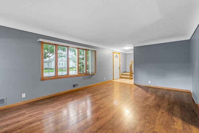 1218 4th Ave SE, Austin, MN 55912 - unfurnished room featuring stairs and wood-type flooring