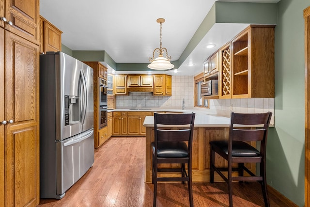 1218 4th Ave SE, Austin, MN 55912 - kitchen featuring appliances with stainless steel finishes, a peninsula, light countertops, light wood-type flooring, and recessed lighting