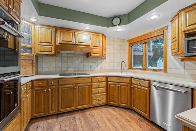 1218 4th Ave SE, Austin, MN 55912 - kitchen with appliances with stainless steel finishes, light countertops, brown cabinetry, decorative backsplash, and recessed lighting