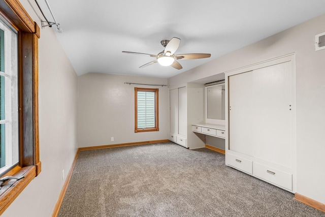 1218 4th Ave SE, Austin, MN 55912 - unfurnished bedroom featuring light colored carpet, multiple closets, a ceiling fan, and a desk