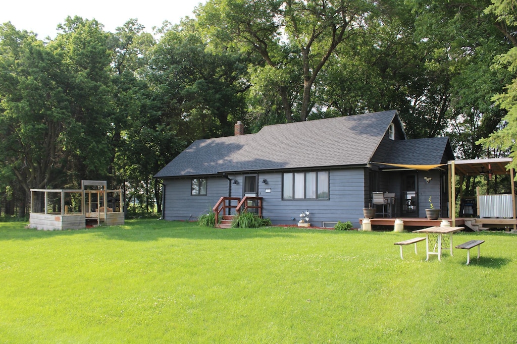 17718 705th Ave, Dassel, MN 55325 - back of house with roof with shingles, a lawn, and a chimney