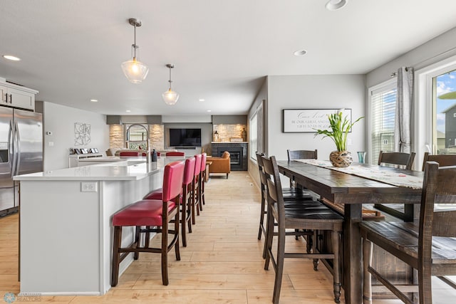 5480 Tanner Ave S, Fargo, ND 58104 - dining room featuring light wood-style flooring, a fireplace, and recessed lighting