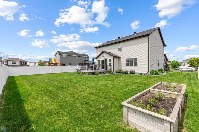 5480 Tanner Ave S, Fargo, ND 58104 - rear view of house featuring a garden, a wooden deck, and a playground