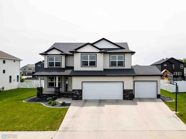 5480 Tanner Ave S, Fargo, ND 58104 - view of front of home featuring stone siding, driveway, an attached garage, and roof with shingles