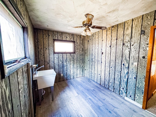 2284 15th St, Johnstown Twp, WI 54826 - unfurnished room with wood-type flooring, a ceiling fan, and wood walls