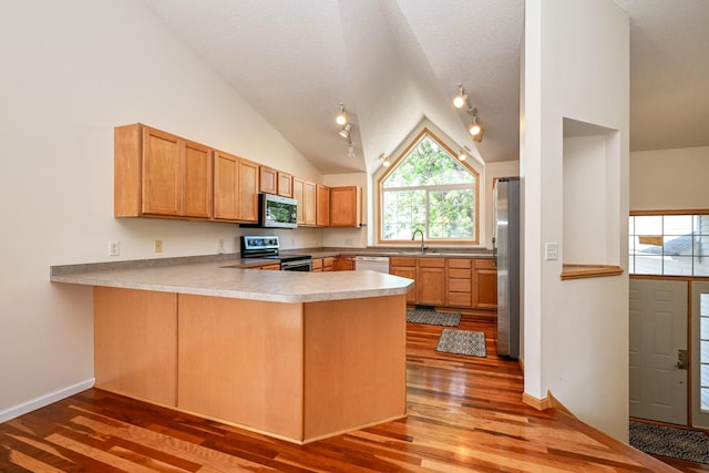 1212 Francis Dr, Elko New Market, MN 55054 - kitchen with appliances with stainless steel finishes, light wood-type flooring, a peninsula, vaulted ceiling, and light countertops