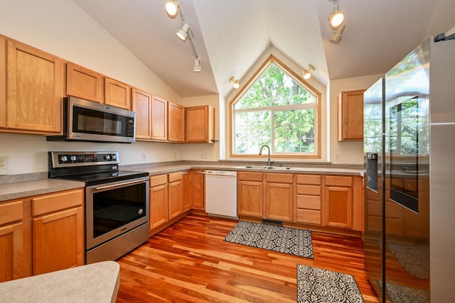 1212 Francis Dr, Elko New Market, MN 55054 - kitchen featuring stainless steel appliances, lofted ceiling, track lighting, light wood-type flooring, and light countertops