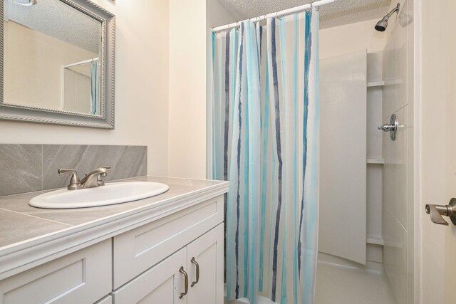 1212 Francis Dr, Elko New Market, MN 55054 - bathroom with vanity, a shower with curtain, a textured ceiling, and decorative backsplash