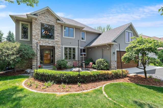 2334 Veterans Memorial Blvd NW, Andover, MN 55304 - view of front of property with stone siding, concrete driveway, a front lawn, a garage, and a patio