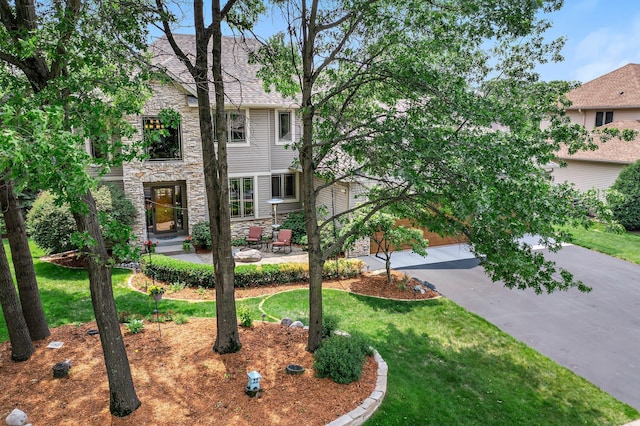 2334 Veterans Memorial Blvd NW, Andover, MN 55304 - view of front of property with stone siding, a front lawn, and a patio