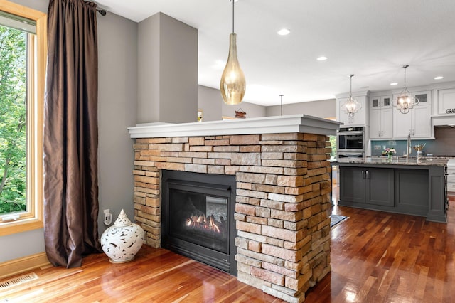 2334 Veterans Memorial Blvd NW, Andover, MN 55304 - detailed view of wood finished floors, recessed lighting, a stone fireplace, and backsplash