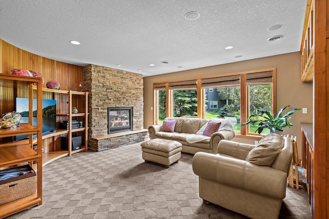 2334 Veterans Memorial Blvd NW, Andover, MN 55304 - living room featuring a textured ceiling, wood walls, carpet, a stone fireplace, and recessed lighting