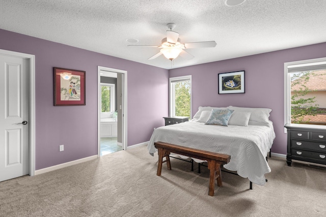 2334 Veterans Memorial Blvd NW, Andover, MN 55304 - carpeted bedroom featuring multiple windows, connected bathroom, a ceiling fan, and a textured ceiling