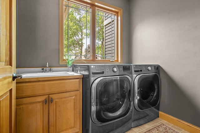 2334 Veterans Memorial Blvd NW, Andover, MN 55304 - laundry room featuring washer and dryer, cabinet space, healthy amount of natural light, and light tile patterned flooring