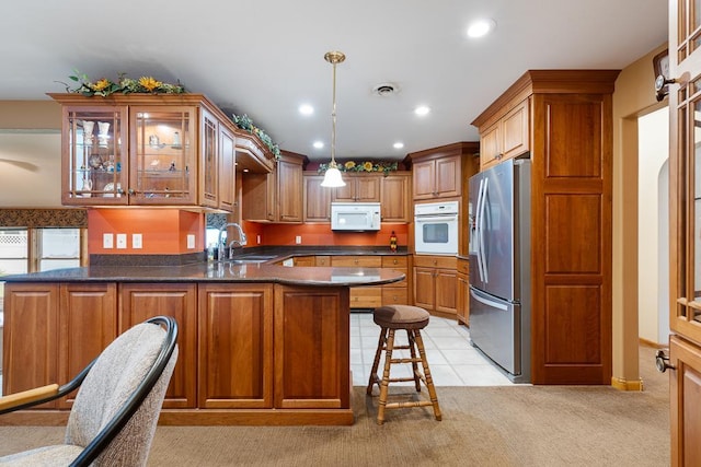 109 Pine Ave N, Canby, MN 56220 - kitchen with white appliances, a peninsula, glass insert cabinets, recessed lighting, and brown cabinetry