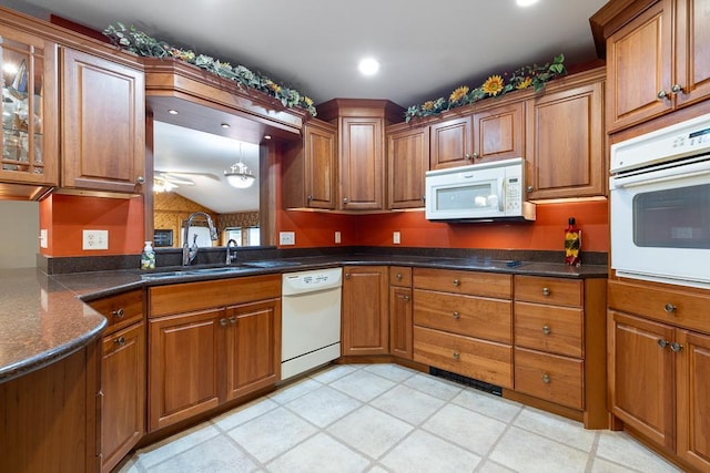 109 Pine Ave N, Canby, MN 56220 - kitchen with white appliances, a ceiling fan, brown cabinetry, dark countertops, and glass insert cabinets
