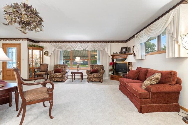 109 Pine Ave N, Canby, MN 56220 - carpeted living room with plenty of natural light, a baseboard heating unit, and a glass covered fireplace