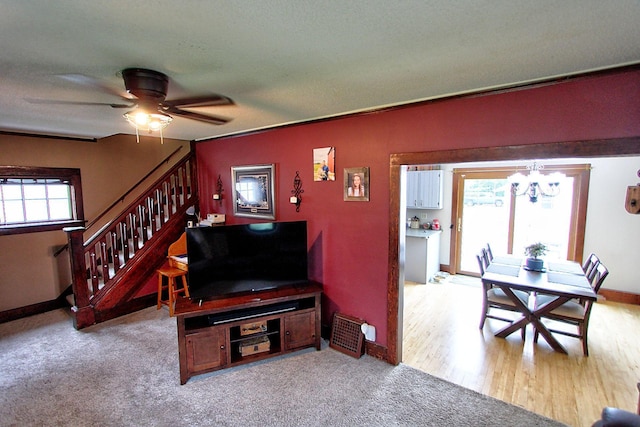 1936 5th St, Red Wing, MN 55066 - carpeted living room with stairs, a chandelier, and a ceiling fan