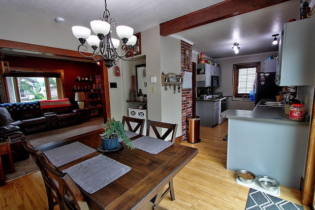 1936 5th St, Red Wing, MN 55066 - dining area with light wood-style flooring, a chandelier, and beam ceiling