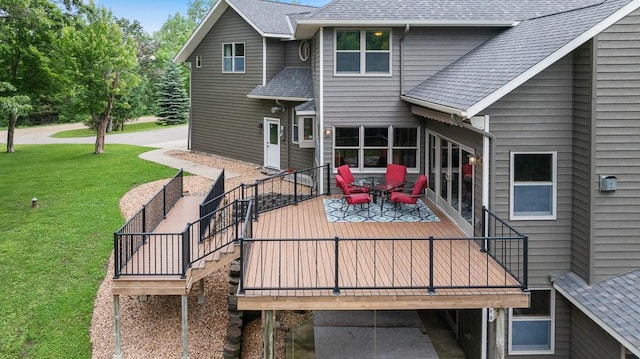 18505 210th Ave NE, Paynesville, MN 56362 - back of property featuring a shingled roof, a lawn, a wooden deck, and stairway