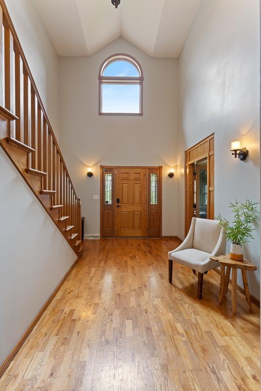 18505 210th Ave NE, Paynesville, MN 56362 - entrance foyer with high vaulted ceiling, stairway, and light wood finished floors