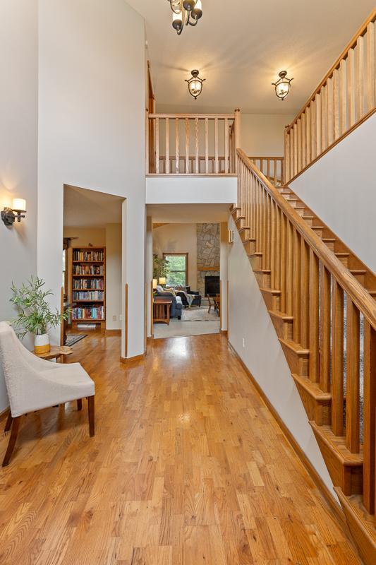 18505 210th Ave NE, Paynesville, MN 56362 - entrance foyer with a stone fireplace, a high ceiling, stairs, and wood finished floors